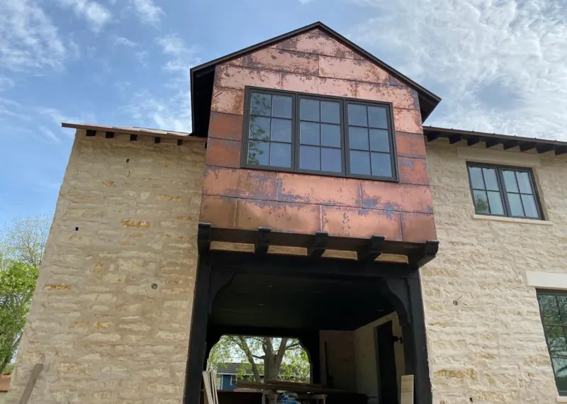 Copper metal panel facade on a stone building for Roof Repair in Walled Lake